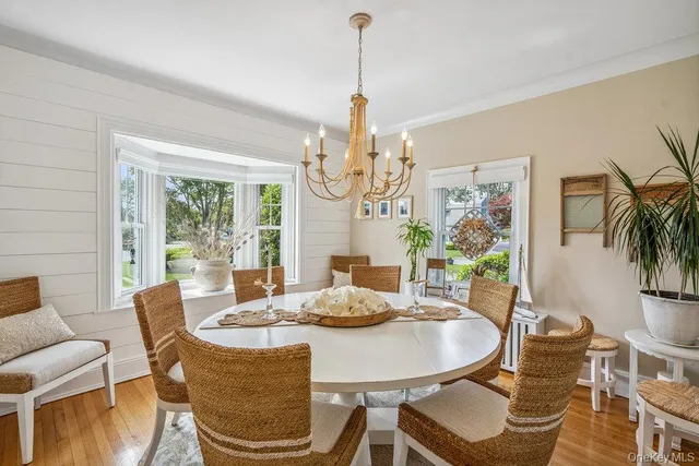 a dining room with furniture a large window and wooden floor