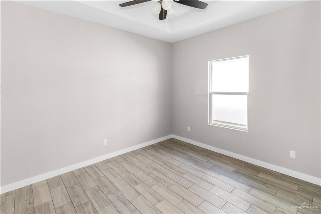 3186 Briggs Road, Unit 1 Weslaco, TX 78596 - Photo 11 of 13 an empty room with a window and a ceiling fan