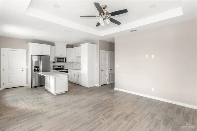 a view of a kitchen with furniture and wooden floor