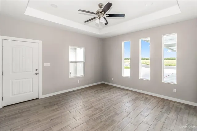 an empty room with a window and a fan