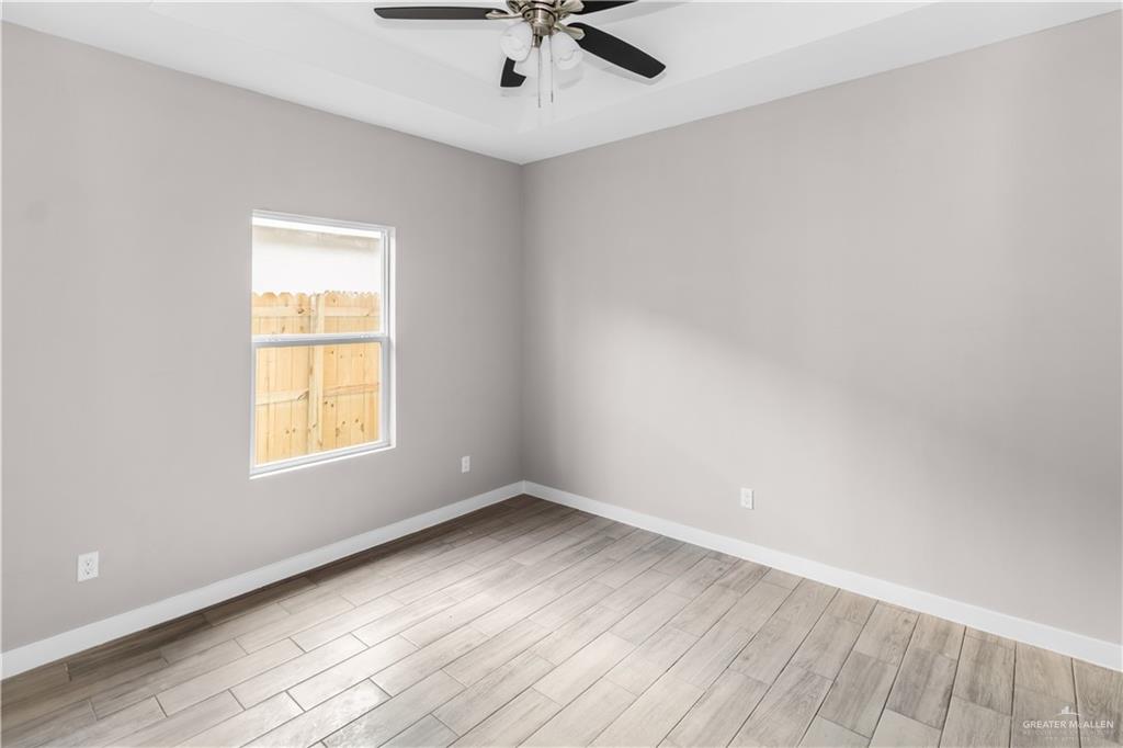 3186 Briggs Road, Unit 1 Weslaco, TX 78596 - Photo 9 of 13 an empty room with a window and a fan