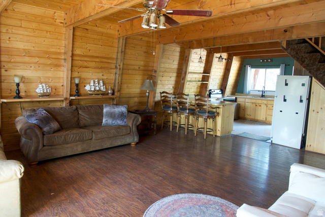 140 East Rim Road Duck Creek Village, UT 84762 - Photo 36 of 45 Living room featuring dark wood-type flooring, a ceiling fan, and wood walls
