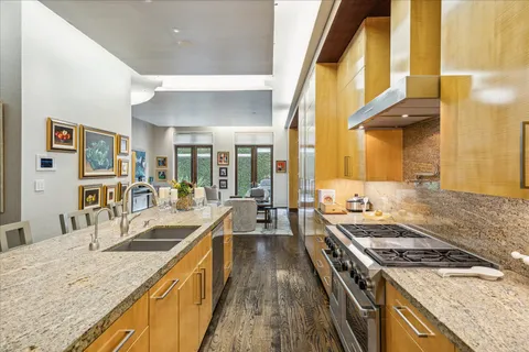 a kitchen with a stove a sink a refrigerator and a dining table view