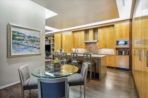 a dining room with furniture a large window and wooden floor