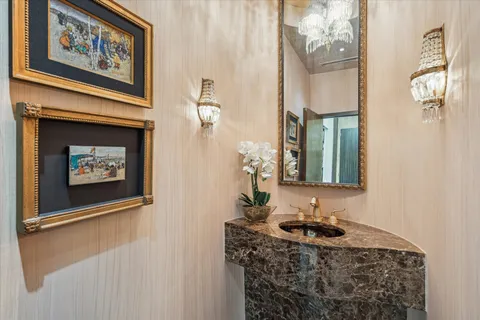 a bathroom with a granite countertop sink a mirror and a picture on the wall