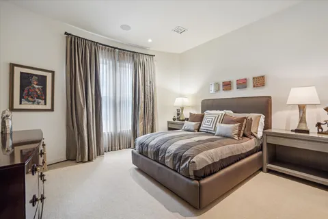 a bedroom with a bed lamp and a large window