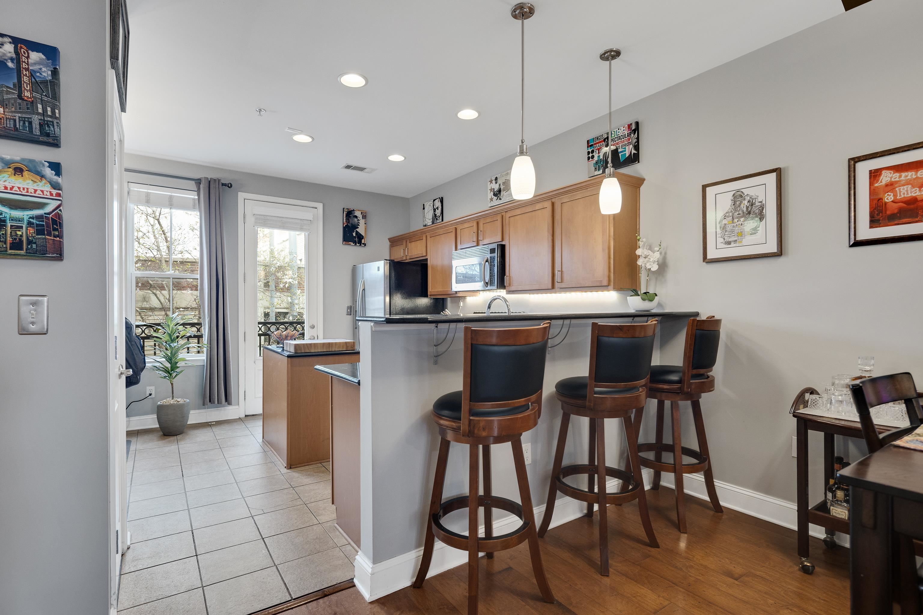79 Shoemaker Court, Unit 108 Memphis, TN 38103 - Photo 10 of 33 a kitchen with a table chairs refrigerator and microwave