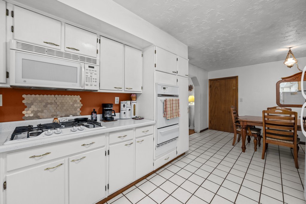 11213 22nd Street Milan, IL 61264 - Photo 27 of 36 a kitchen with granite countertop a sink cabinets and stove top oven