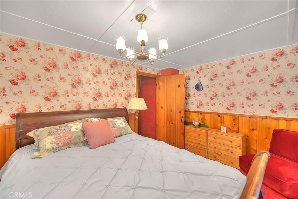 5926 Pine Street Wrightwood, CA 92397 - Photo 21 of 66 a bedroom with a bed and a chandelier