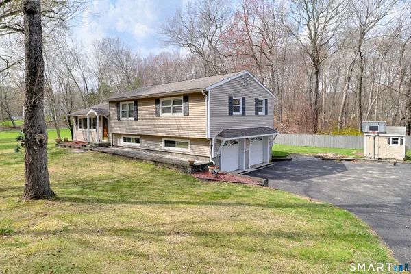 a view of a house with a yard covered with trees
