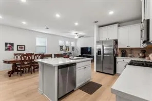 a kitchen with a sink a counter top stainless steel appliances and cabinets