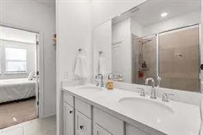 a en suite bathroom with double sink and a mirror