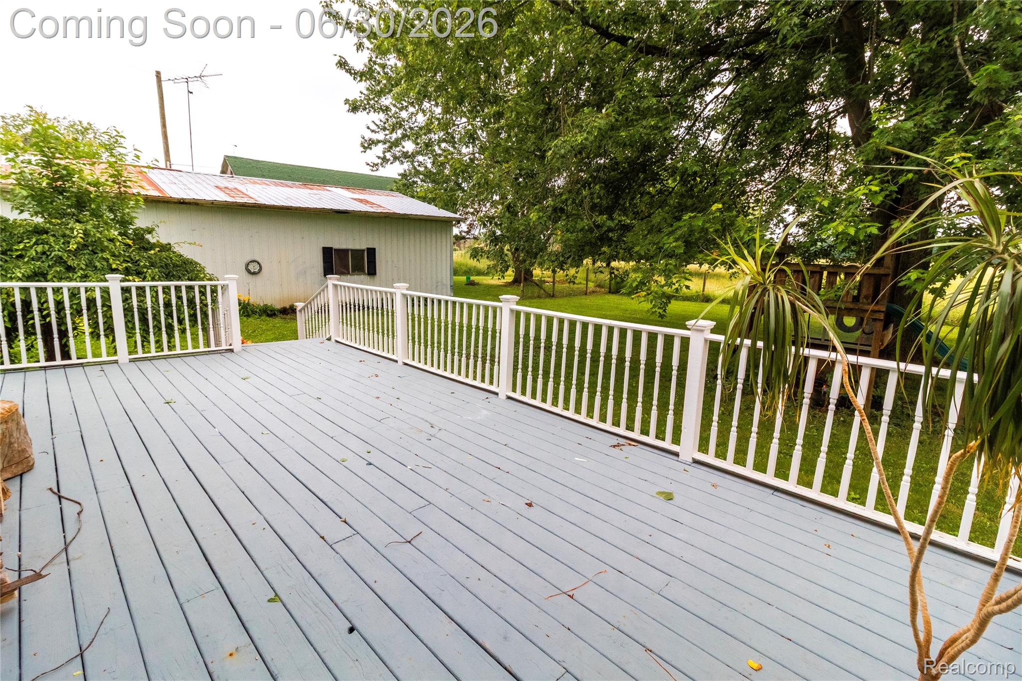 8150 Norman Road Imlay City, MI 48444 - Photo 4 of 58 Spacious exterior deck with white baluster railing and gray-painted wood-finish flooring