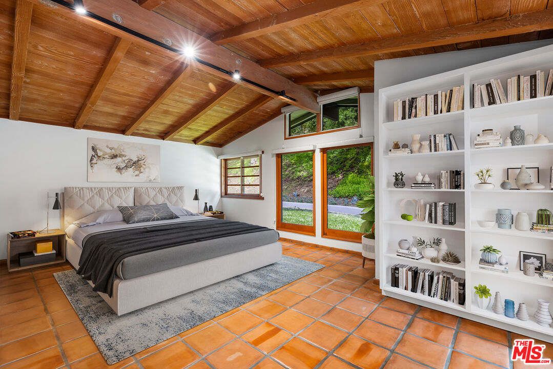 1776 Old Ranch Road Los Angeles, CA 90049 - Photo 8 of 24 a spacious bedroom with a bed and a book shelf
