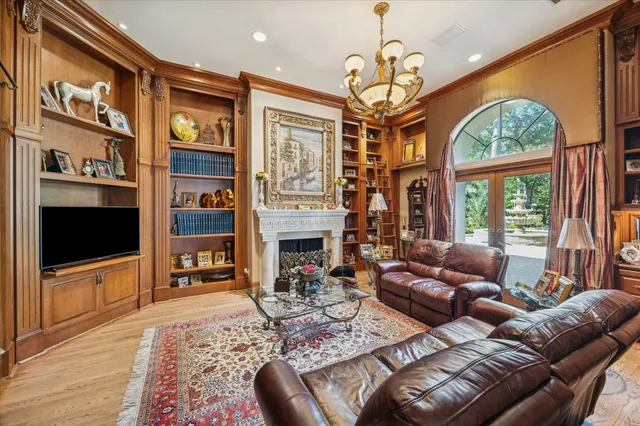a living room with furniture a flat screen tv and a floor to ceiling window