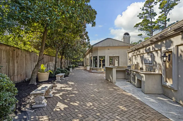 a view of a patio with table and chairs and a barbeque with potted plants