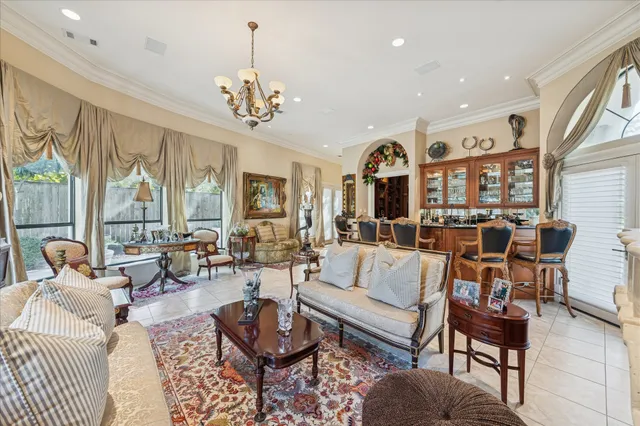 a living room with furniture chandelier and a large window