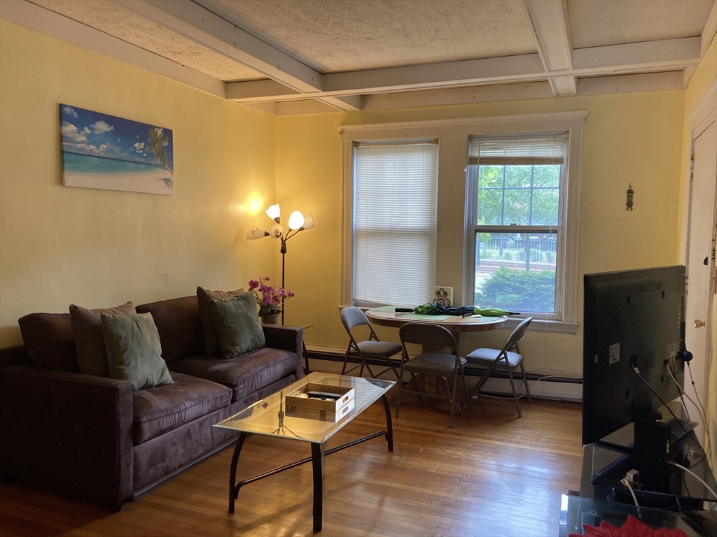 1734 Commonwealth Avenue, Unit 4 Boston, MA 02135 - Photo 11 of 15 a living room with furniture a window and a flat screen tv