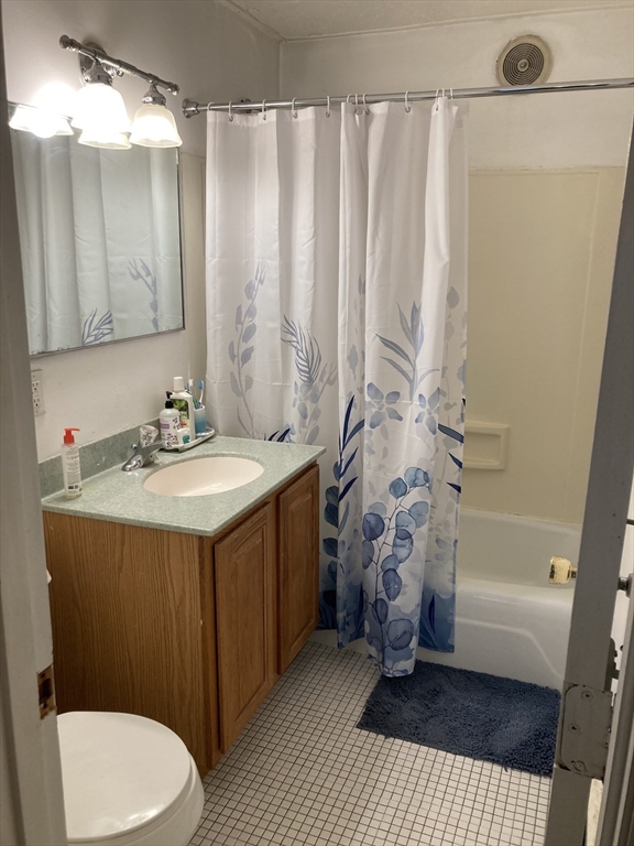 1734 Commonwealth Avenue, Unit 4 Boston, MA 02135 - Photo 14 of 15 a bathroom with a sink a toilet a mirror and shower