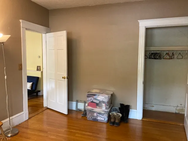 a view of a room with wooden floor cabinet and bathroom