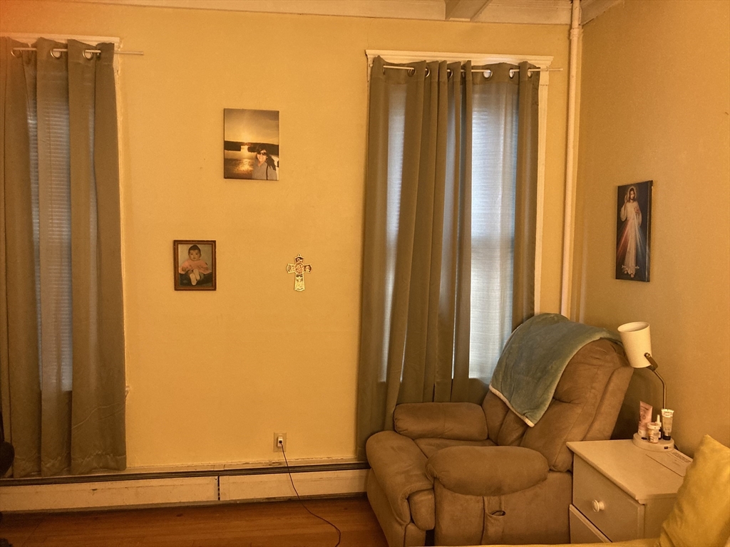 1734 Commonwealth Avenue, Unit 4 Boston, MA 02135 - Photo 7 of 15 a blue couch sitting in a bathroom next to a window