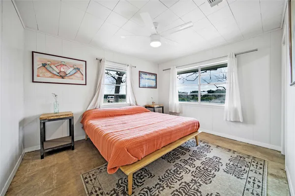 a bedroom with a bed and a lamp on dresser