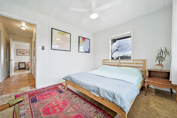 a bedroom with a bed a table and chair