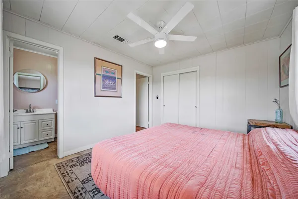 a bedroom with a bed and a painting on the wall