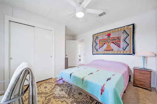 a bedroom with a bed and a lamp on dresser
