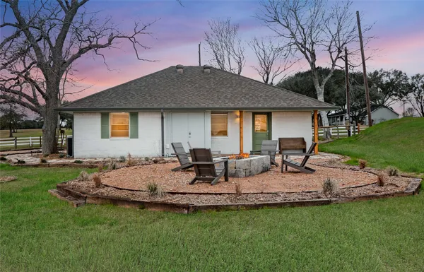 a front view of a house with a garden and trees