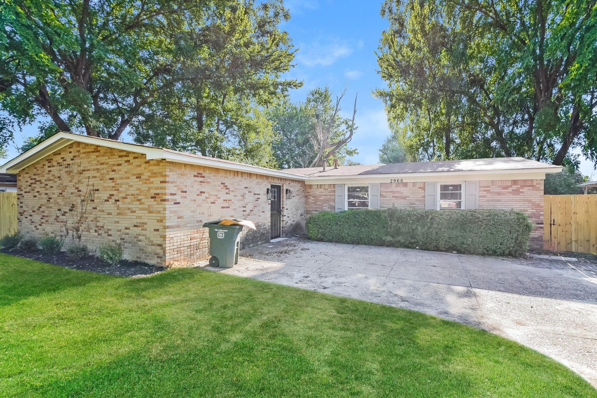a view of a house with a yard and a tree