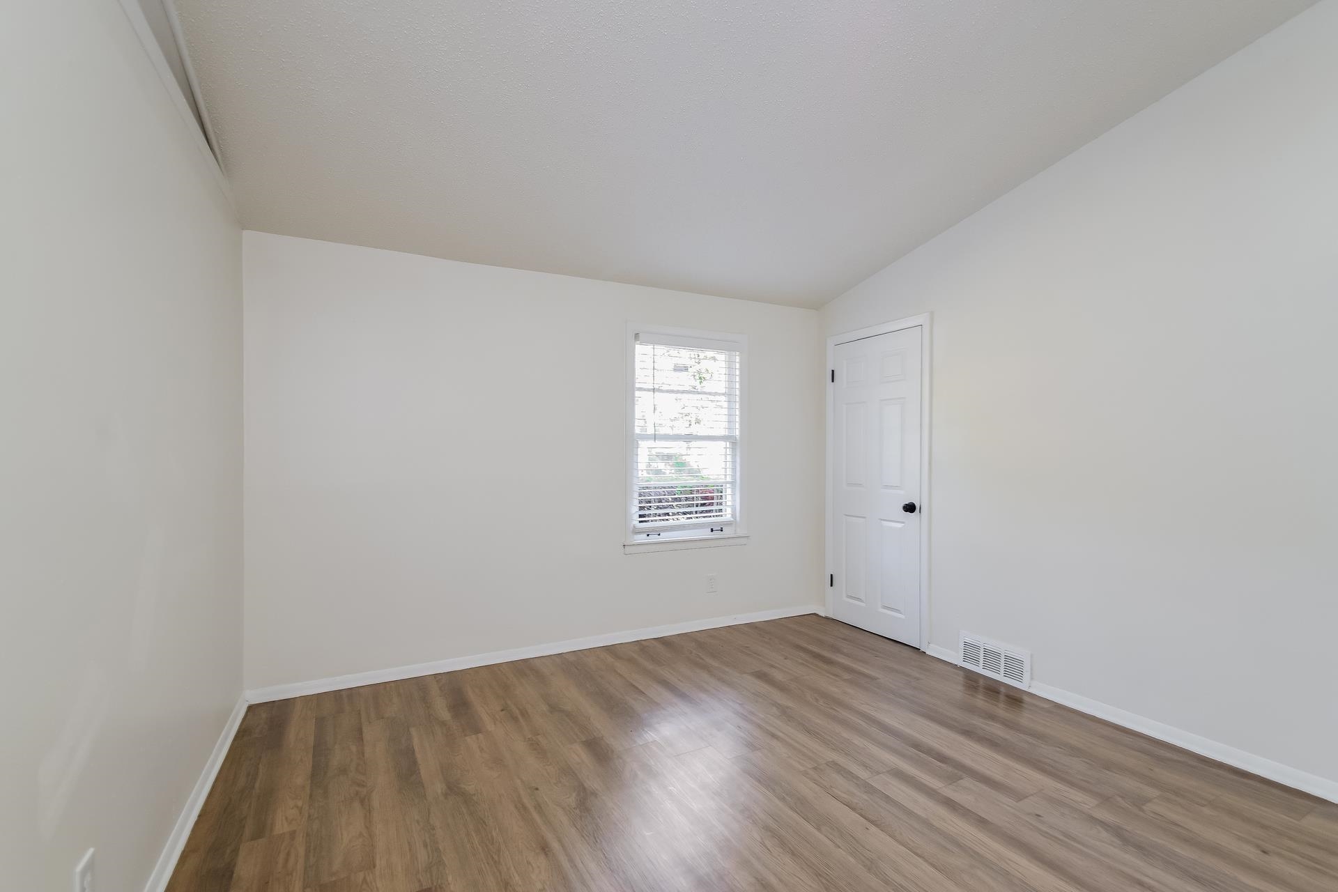 2966 Knight Road Memphis, TN 38118 - Photo 16 of 19 a view of an empty room with wooden floor and window