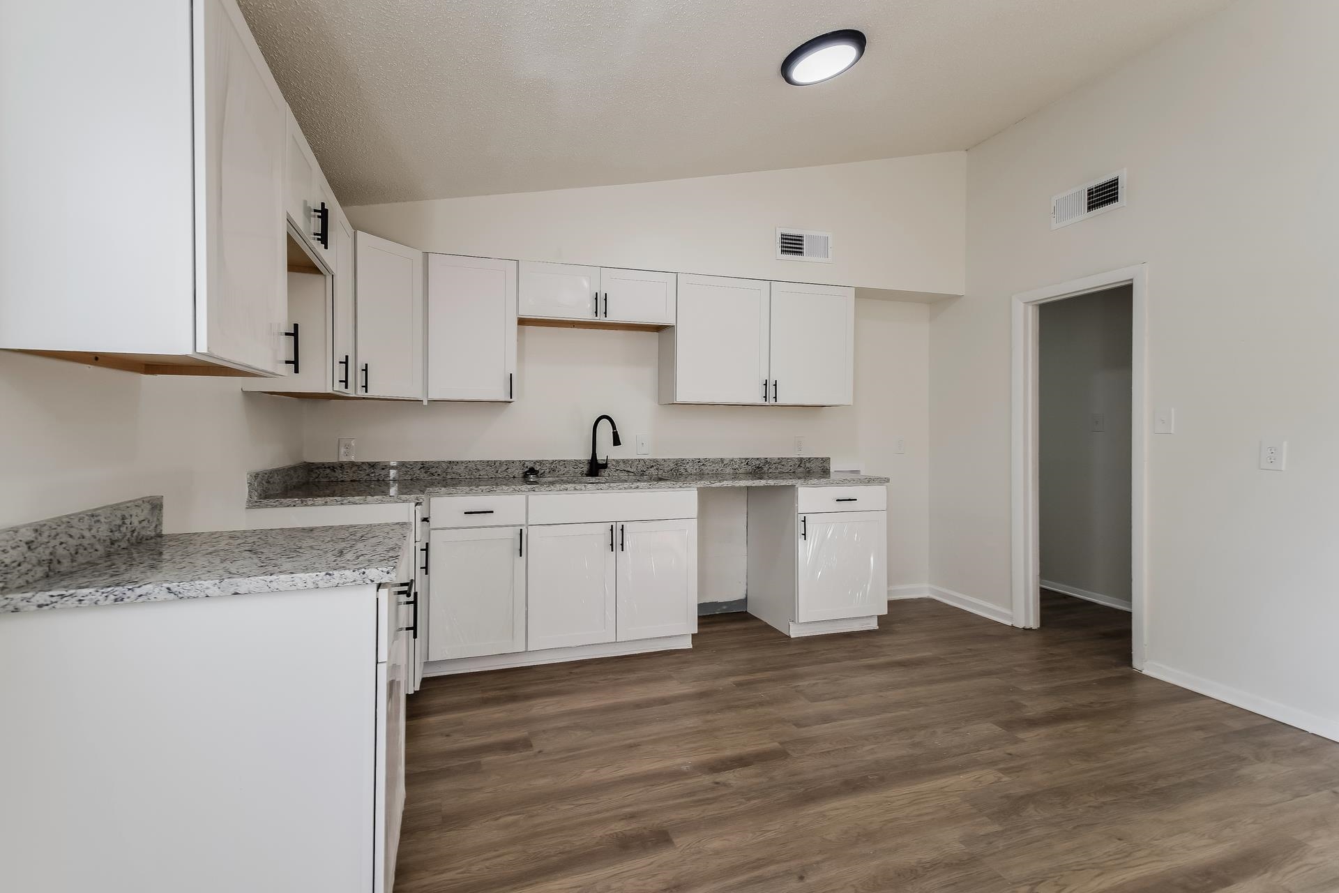 2966 Knight Road Memphis, TN 38118 - Photo 7 of 19 a kitchen with granite countertop white cabinets and white appliances