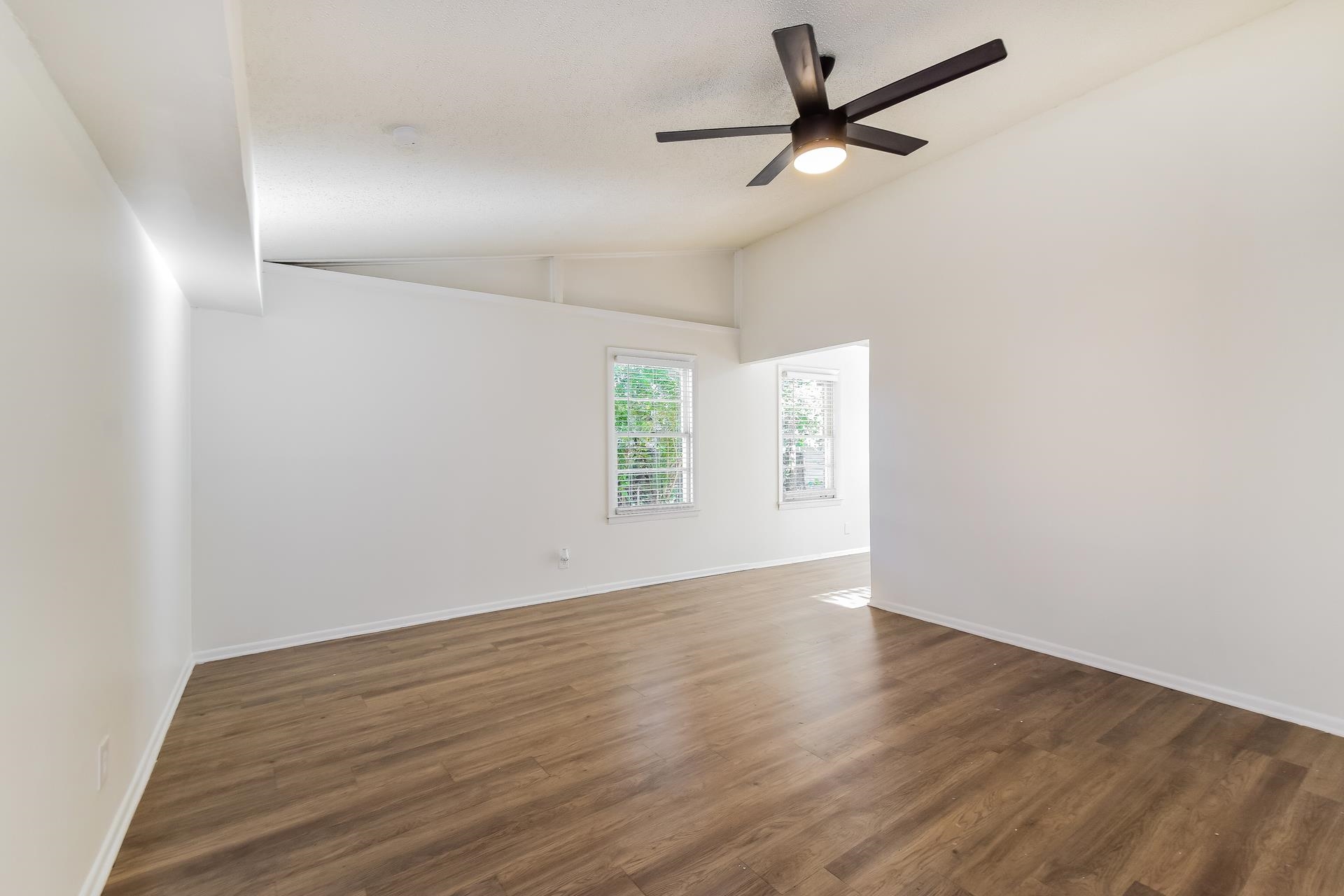 2966 Knight Road Memphis, TN 38118 - Photo 8 of 19 an empty room with wooden floor ceiling fan and windows