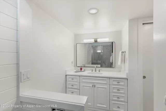 a bathroom with a sink vanity granite and a mirror