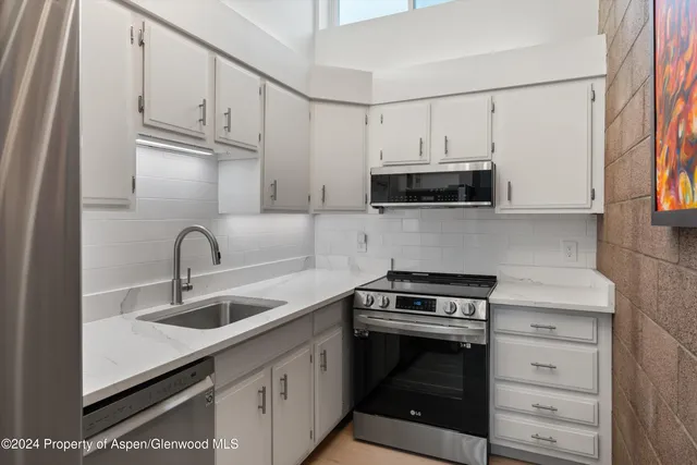 a kitchen with cabinets stainless steel appliances and a sink
