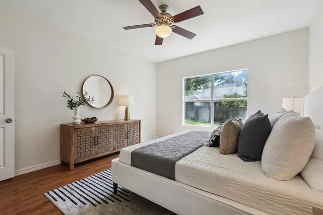 a bedroom with a bed wooden floor and window