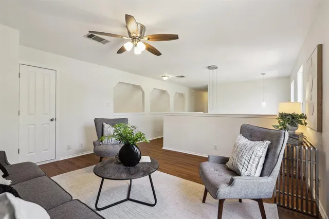a living room with furniture and wooden floor