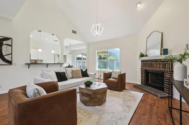 a living room with furniture a fireplace and a large window