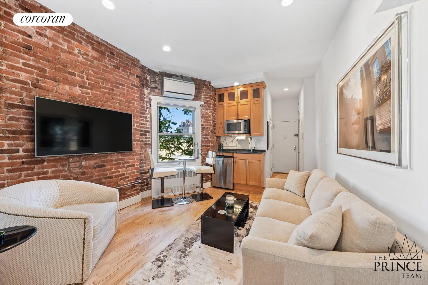 77 Perry Street, Unit 5D Manhattan, NY 10014 - Photo 2 of 7 a living room with furniture and a flat screen tv