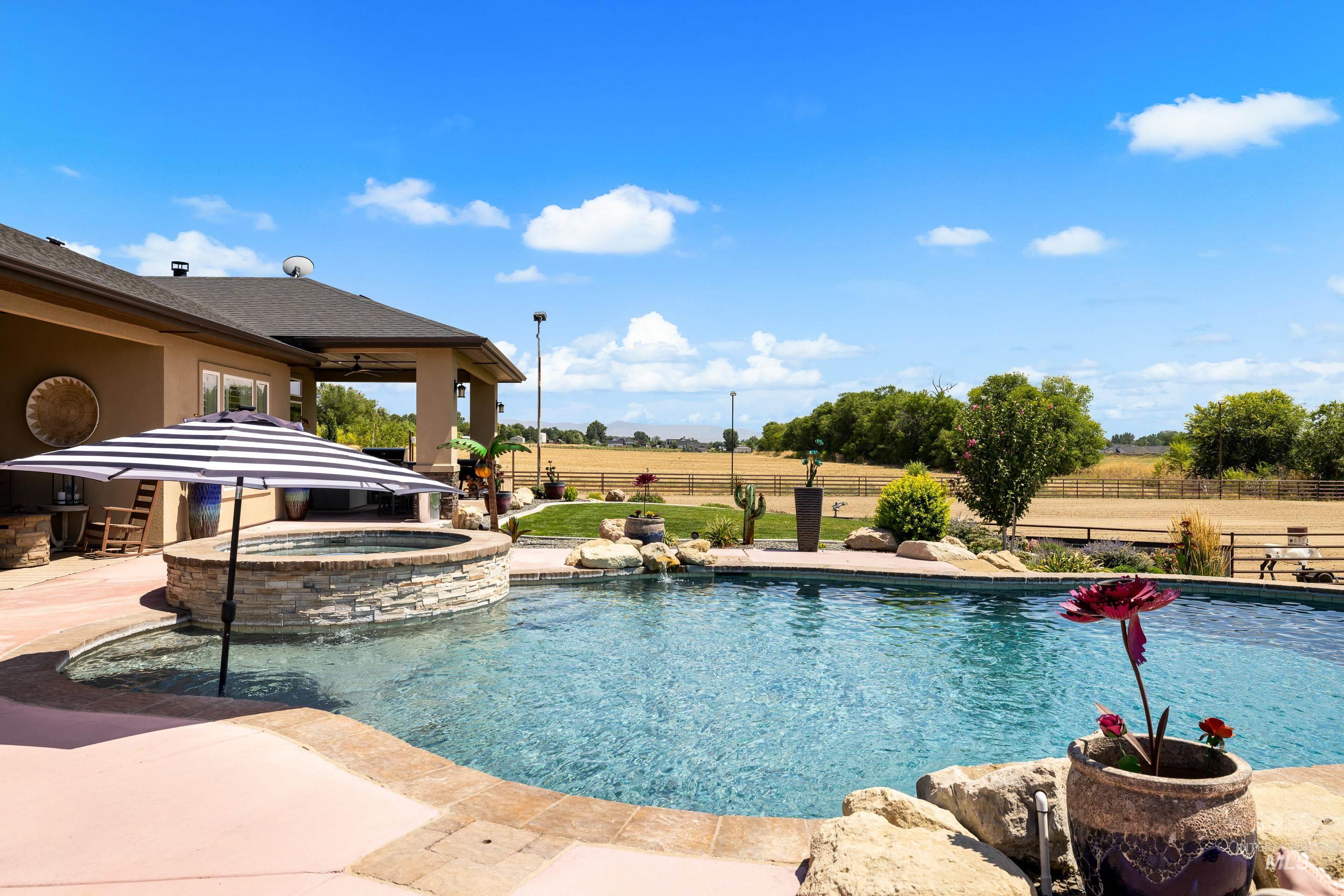 9819 Foothill Road Middleton, ID 83644 - Photo 38 of 49 View of swimming pool with a patio, a pool with connected hot tub, and a view of rural / pastoral area