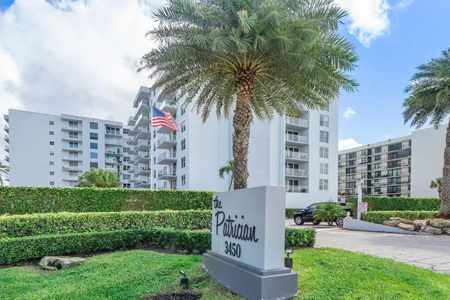 a front view of multi story residential apartment building with yard and green space