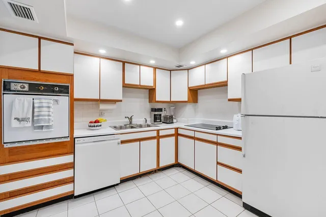 a kitchen with granite countertop cabinets stainless steel appliances and a sink
