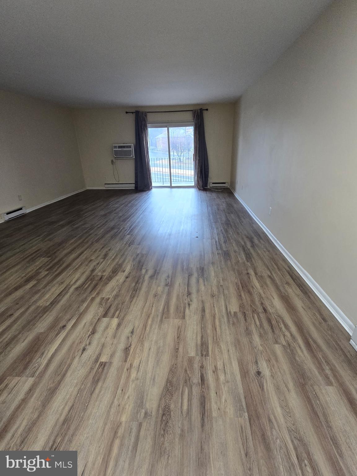 94 Governor Printz Boulevard, Unit 8 Claymont, DE 19703 - Photo 11 of 17 a view of an empty room with wooden floor and window