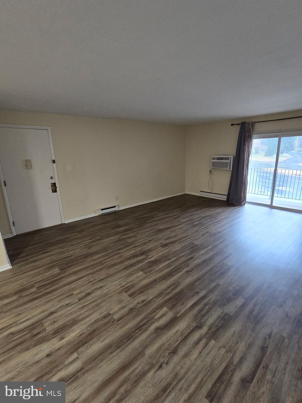 94 Governor Printz Boulevard, Unit 8 Claymont, DE 19703 - Photo 12 of 17 a view of an empty room with wooden floor and a window