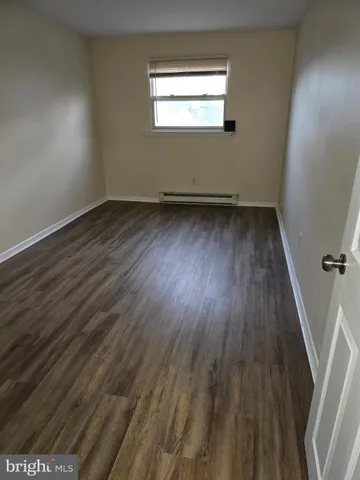 a view of a room with wooden floor and window