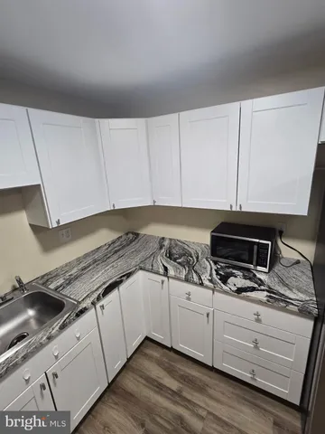 a kitchen with granite countertop white cabinets and white appliances