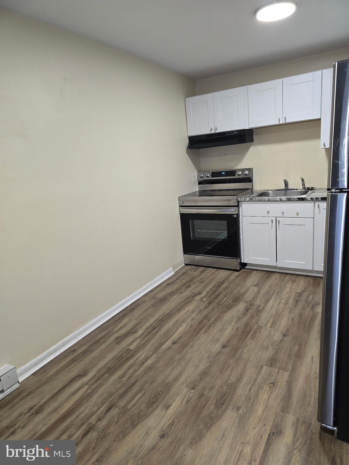 94 Governor Printz Boulevard, Unit 8 Claymont, DE 19703 - Photo 7 of 17 a kitchen with granite countertop a stove and a refrigerator