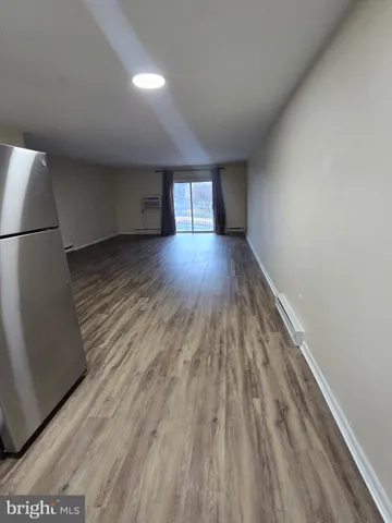 a view of empty room with wooden floor and window