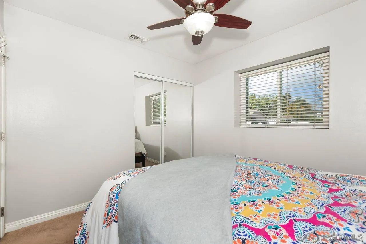 14525 Garden Road Poway, CA 92064 - Photo 18 of 25 a bedroom with a bed and a chandelier fan